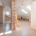 Interior of a loft with a wooden ladder and skylights