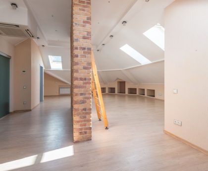 Interior of a loft with a wooden ladder and skylights