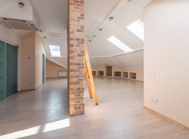Interior of a loft with a wooden ladder and skylights